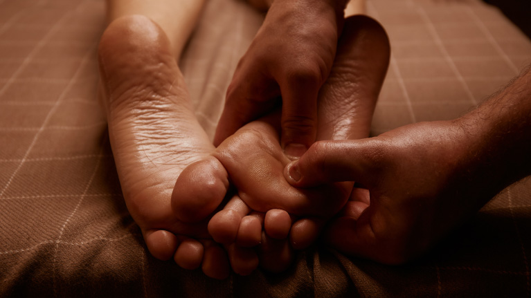 therapist massaging pressure points in foot